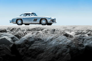 Silver Mercedes-Benz car on a rocky terrain with a clear blue sky