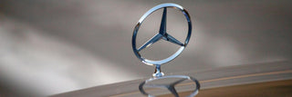Mercedes-Benz logo on a car hood with a blurred background